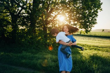 Huysuz anne ve yakışıklı oğul doğada eğleniyor. Mutlu aile kavramı. Aile hayatı olan güzel doğa manzarası. Mutlu bir aile birlikte dinleniyor. Aile yaşamında mutluluk. Anneler Günü.