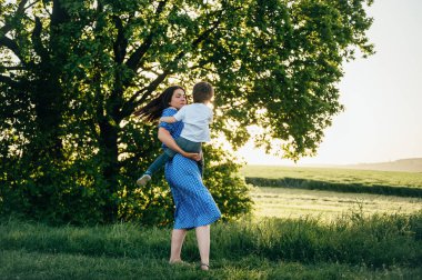 Huysuz anne ve yakışıklı oğul doğada eğleniyor. Mutlu aile kavramı. Aile hayatı olan güzel doğa manzarası. Mutlu bir aile birlikte dinleniyor. Aile yaşamında mutluluk. Anneler Günü.