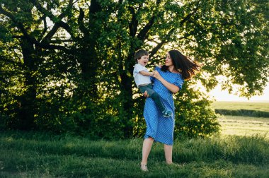 Huysuz anne ve yakışıklı oğul doğada eğleniyor. Mutlu aile kavramı. Aile hayatı olan güzel doğa manzarası. Mutlu bir aile birlikte dinleniyor. Aile yaşamında mutluluk. Anneler Günü.