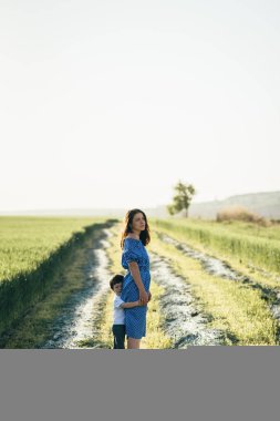 Stilish anne ve yakışıklı oğlu doğa üzerinde eğleniyor. Mutlu aile kavramı. Aile açık hava yaşam tarzı ile güzellik doğa sahne. Mutlu bir aile birlikte dinlenme. Mutluluk ve uyum içinde aile hayatı. Anneler günü.