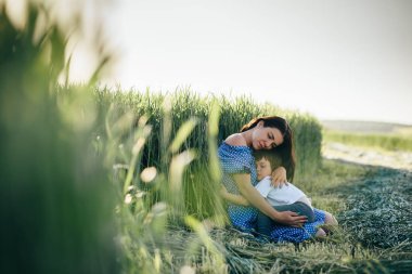 Stilish anne ve yakışıklı oğlu doğa üzerinde eğleniyor. Mutlu aile kavramı. Aile açık hava yaşam tarzı ile güzellik doğa sahne. Mutlu bir aile birlikte dinlenme. Mutluluk ve uyum içinde aile hayatı. Anneler günü.