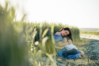 Stilish anne ve yakışıklı oğlu doğa üzerinde eğleniyor. Mutlu aile kavramı. Aile açık hava yaşam tarzı ile güzellik doğa sahne. Mutlu bir aile birlikte dinlenme. Mutluluk ve uyum içinde aile hayatı. Anneler günü.