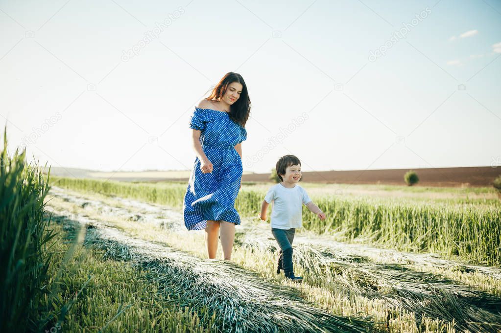 Stilish mother and handsome son having fun on the nature. Happy family concept. Beauty nature scene with family outdoor lifestyle. Happy family resting together. Happiness in family life. Mothers day.