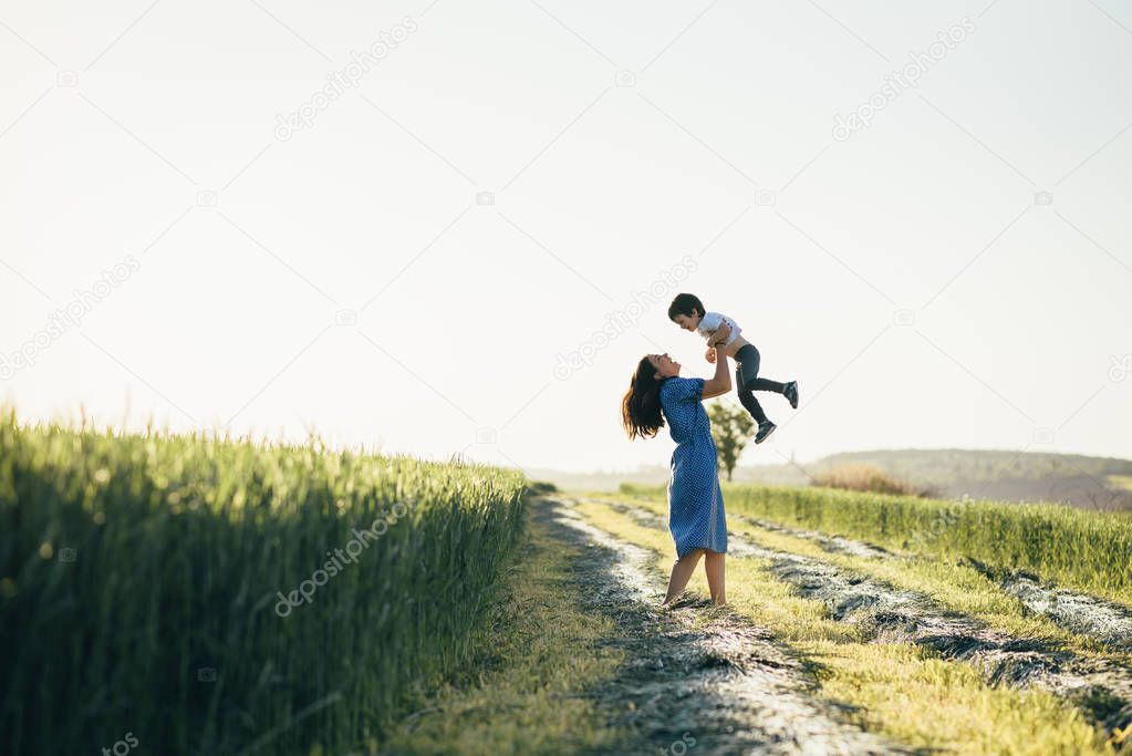 Stilish mother and handsome son having fun on the nature. Happy family concept. Beauty nature scene with family outdoor lifestyle. Happy family resting together. Happiness and harmony in family life. Mothers day.