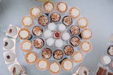 Taze, egzotik, organik meyveler, açık büfe masasında hafif atıştırmalıklar. Mini yemekler, abur cuburlar, etkinliklerde restoran yemekleri. Parti malzemeleri için dekore edilmiş nefis bir masa. Kekler ve brovniler açık büfe masasının üzerinde duruyor.