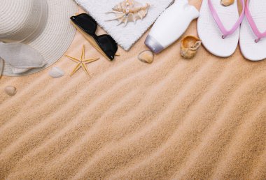 Kumlu plaja havlu çerçeve ve yaz aksesuarları ile en iyi görünümü. Arka plan kopya alanı ve görünür kum doku ile. Sol Kenarlık havlu ile yapılan