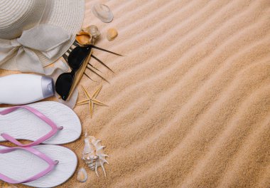 Kumlu plaja havlu çerçeve ve yaz aksesuarları ile en iyi görünümü. Arka plan kopya alanı ve görünür kum doku ile. Sol Kenarlık havlu ile yapılan