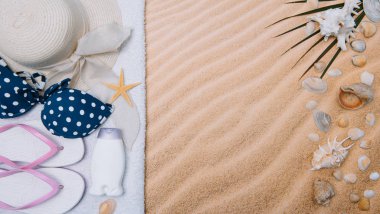 Kumlu plaja havlu çerçeve ve yaz aksesuarları ile en iyi görünümü. Arka plan kopya alanı ve görünür kum doku ile. Sol Kenarlık havlu ile yapılan