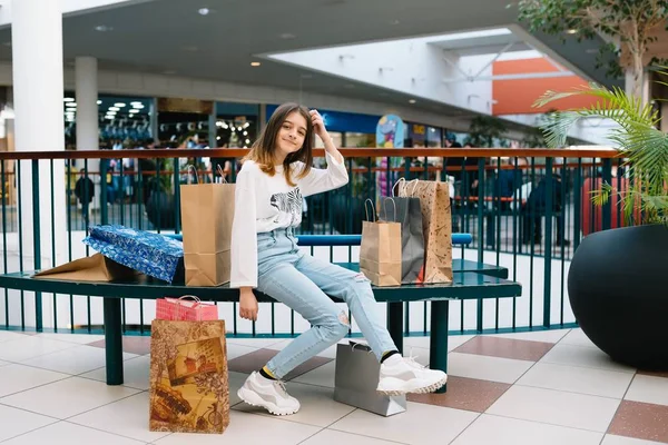 Gyönyörű fiatal anya és tizenéves lánya gazdaság bevásárló táska, vásárlás a plázában. Családi vásárlás. — Stock Fotó