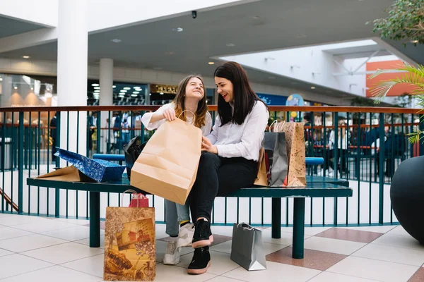 Gyönyörű fiatal anya és tizenéves lánya gazdaság bevásárló táska, vásárlás a plázában. Családi vásárlás. — Stock Fotó