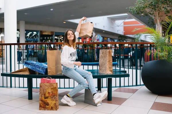 Conceito de varejo, gesto e venda - menina adolescente sorridente com muitos sacos de compras no shopping. conceito de compras — Fotografia de Stock