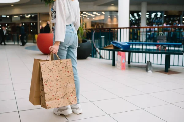 Tempo de compras, close-up de pernas de menina adolescente com sacos de compras no shopping — Fotografia de Stock