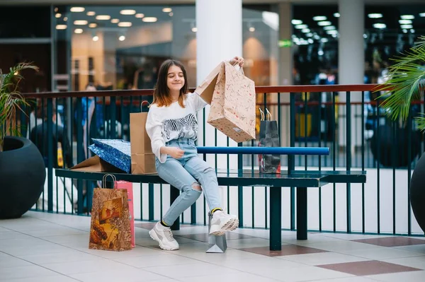 Tempo de compras, menina adolescente com sacos de compras no shopping center. Conceito de compras — Fotografia de Stock