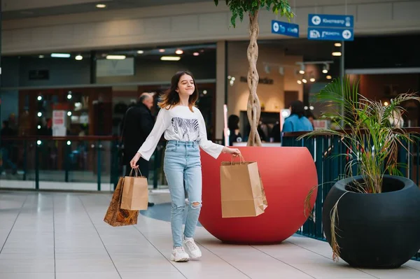 Conceito de varejo, gesto e venda - menina adolescente sorridente com muitos sacos de compras no shopping — Fotografia de Stock