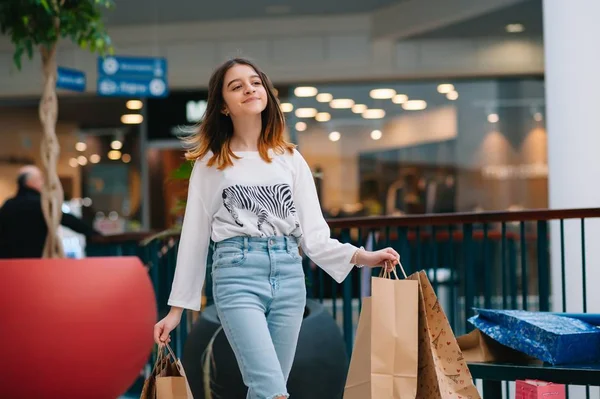 Conceito de varejo, gesto e venda - menina adolescente sorridente com muitos sacos de compras no shopping — Fotografia de Stock