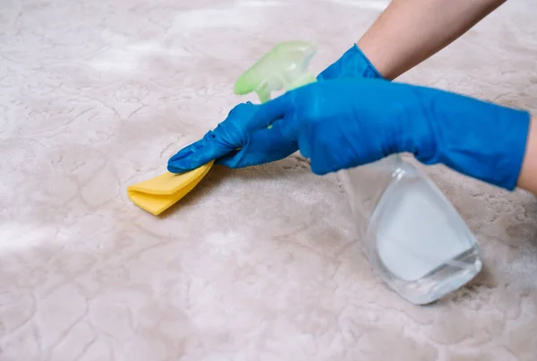 Insanlar, ev işleri ve temizlik konsepti - evde bez ve derergent sprey temizlik halı ile lastik eldiven kadın yakın. kumaş temizleme halı ile kadın yakın çekim — Stok fotoğraf