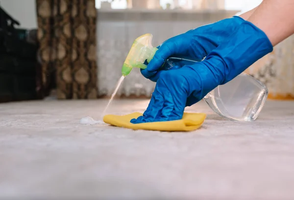 Mensen, huishoudelijk werk en huishouden concept-close-up van de vrouw in rubberen handschoenen met doek en derergent spray schoonmaken tapijt thuis. Close-up van de vrouw met doek reiniging tapijt — Stockfoto