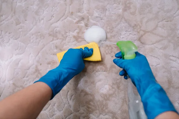 Människor, hushållsarbete och städning koncept-närbild av kvinna i gummihandskar med tyg och derergent Spray rengöring mattan hemma. närbild av kvinna med trasa rengöring mattan — Stockfoto