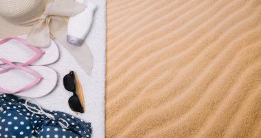 Kumlu plaja havlu çerçeve ve yaz aksesuarları ile en iyi görünümü. Arka plan kopya alanı ve görünür kum doku ile. Sol Kenarlık havlu ile yapılan