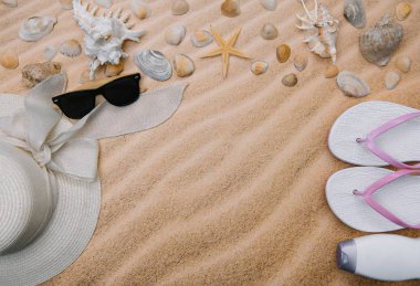 Kabukları ve havlu çerçeve ve yaz aksesuarları ile kumlu plaj üst görünümü. Kopyalama alanı ve görünür kum dokusu ile arka plan. havlu dan yapılmış sol sınır
