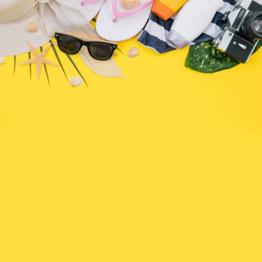 Plaj düz döşeme aksesuarları. Güneş şapkası, bej havlu, sarı kozmetik çantası, kamera, krem, güneş koruyucu şişe, tarak ve deniz kabukları. Yaz seyahati tatil konsepti