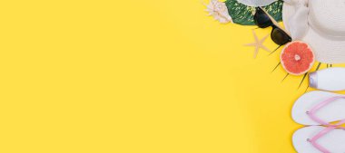 Plaj düz döşeme aksesuarları. Güneş şapkası, bej havlu, sarı kozmetik çantası, kamera, krem, güneş koruyucu şişe, tarak ve deniz kabukları. Yaz seyahati tatil konsepti