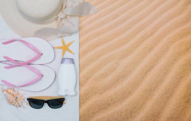 Kumlu plaja havlu çerçeve ve yaz aksesuarları ile en iyi görünümü. Arka plan kopya alanı ve görünür kum doku ile. Sol Kenarlık havlu ile yapılan