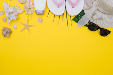 Düz yatıyordu plaj aksesuarları: mayo, güneş gözlüğü, şapka, palmiye dalları ile sandalet, egzotik meyve ve kabukları. Sarı arka planda üstte görünüm