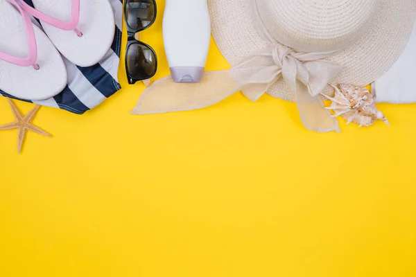Beach flat lay accessories. Sun hat, beige towel, yellow cosmetic bag, camera, cream, sunscreen bottle, comb and seashells. Summer travel holiday concept — Stock Photo, Image