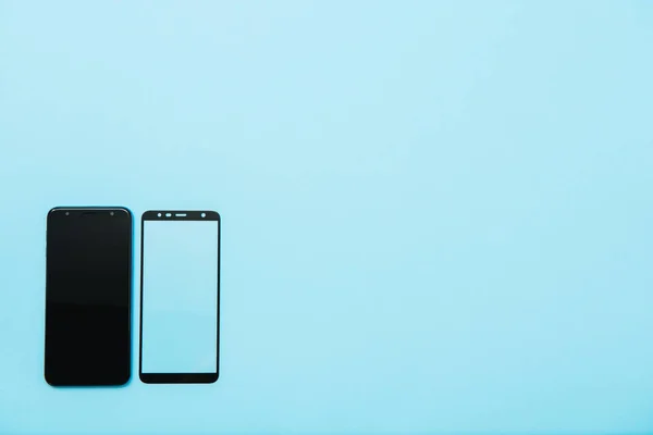 Teléfono inteligente con escudo de vidrio templado, pantalla de película cubierta .protector conceptos ideas. fondo azul — Foto de Stock