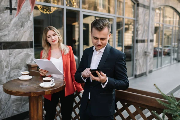 Hombre de negocios guapo y seguro que usa computadora portátil y tecnología Gadget Smartphone al aire libre Discusión con un hermoso socio de negocios .New Modern Business People Lifestyle . — Foto de Stock