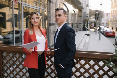Toplantı için hazırlık. Yakın çekim ayakta dışında şehrin birbirimizi mutlu alt gülümseyen belgeleri holding sokak iki genç iş adamları göster