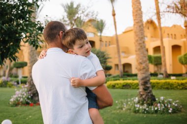 Baba oğlunu kollarında tutuyor, dışarıda eğleniyor..