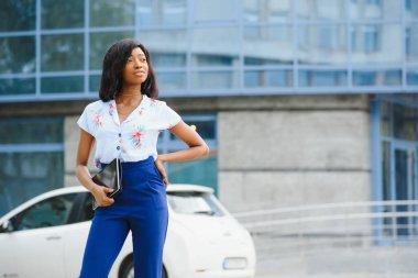 Güzel siyahi kadın şehir arka planında tablet bilgisayar kullanıyor. Başarılı kadın konsepti.