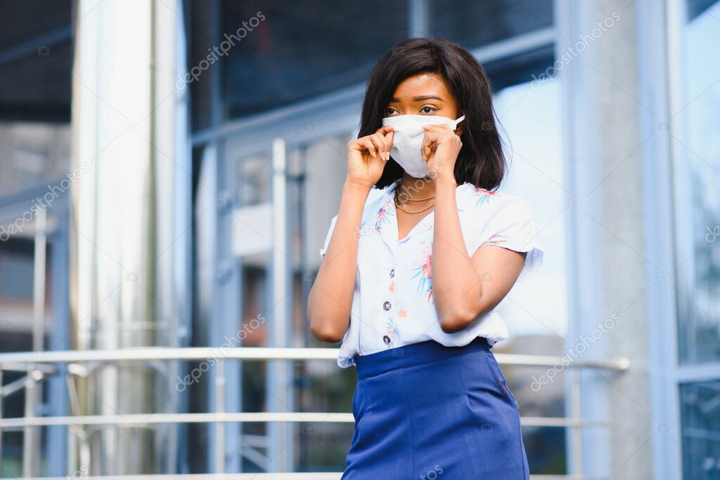 African American businesswoman wearing protective mask on her face in the city. The concept of visiting work during a pandemic