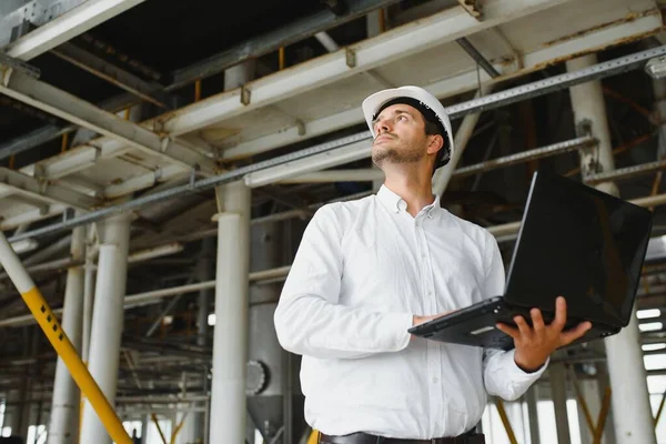 happy male industrial technician inside a factory