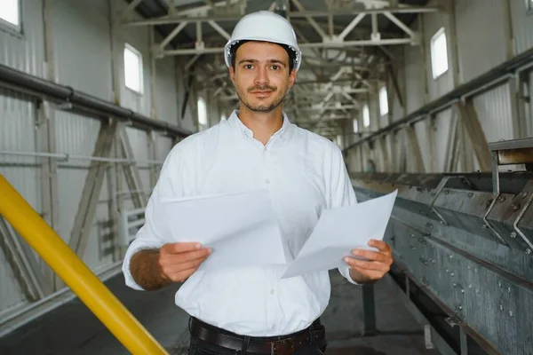 happy male industrial technician inside a factory