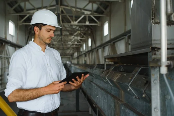 happy male industrial technician inside a factory