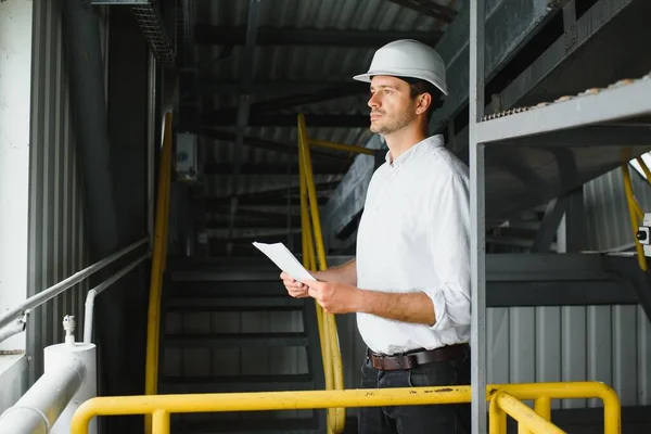 happy male industrial technician inside a factory