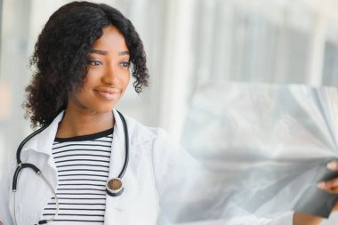 Hastanedeki Afrikalı doktor hastanın röntgenine bakıyor.