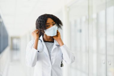 Yüz maskeli çekici bir Afrikalı doktor.