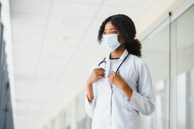 Yüz maskeli çekici bir Afrikalı doktor.