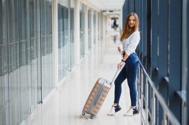Havaalanı terminalinde bavullu güzel bir kız. tatil ve seyahat kavramı