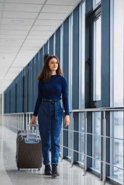 Havaalanında güzel genç bayan yolcu (sığ DOF; renk tonlu resim)