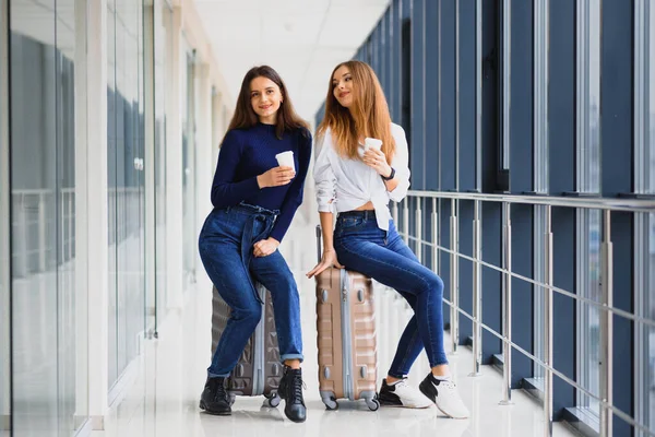 机场的两名妇女坐上飞机 机场的女朋友们带着手提箱 — 图库照片