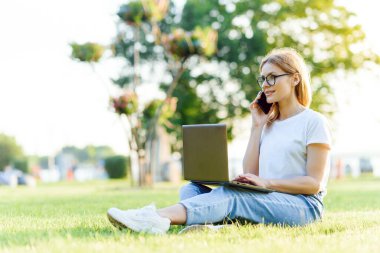 Parkta dizüstü bilgisayarı olan çekici kız.