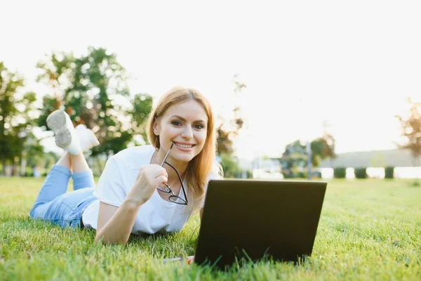 Bella Felice Giovane Donna Sdraiata Sull Erba Circondata Dispositivi Tecnologici — Foto Stock