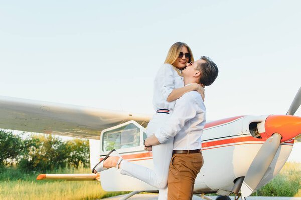 Couple in love having fun near private plane.