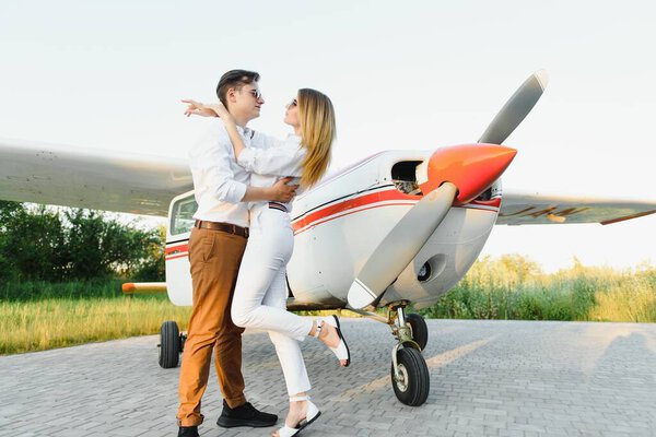 Couple in love hugging near private plane. Selective focus