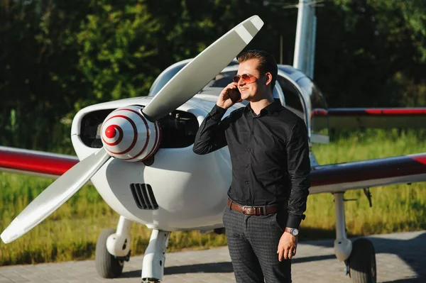 Uçakları Olan Bir Adamı Akıllı Telefonuyla Havaalanında Yürüyor Bir Telefon — Stok fotoğraf